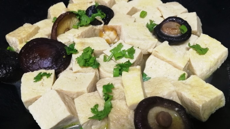 香菇炖豆腐,汤汁快收尽时关火,洒上香葱和香菜末。