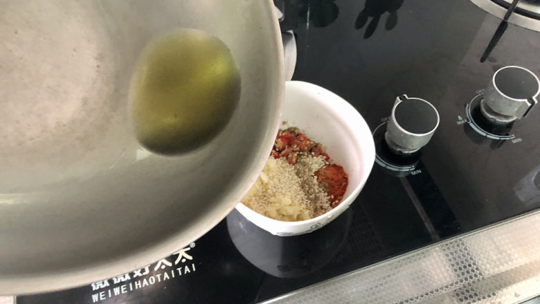 凉拌香干,八成热的热油分次浇在辣椒粉蒜末上,搅拌均匀