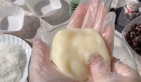 红豆糯米糍,取一块糯米糍,用手按压平,这个具体没有规定多重,自己想做多大都可以