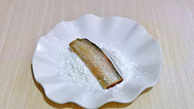 椒盐带鱼,玉米淀粉放入盘中,取一段腌制好的带鱼,均匀裹上淀粉,依次做完。