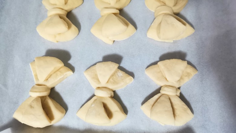 蝴蝶结面包,烤盘放上油纸,做好的蝴蝶结面包放在上面