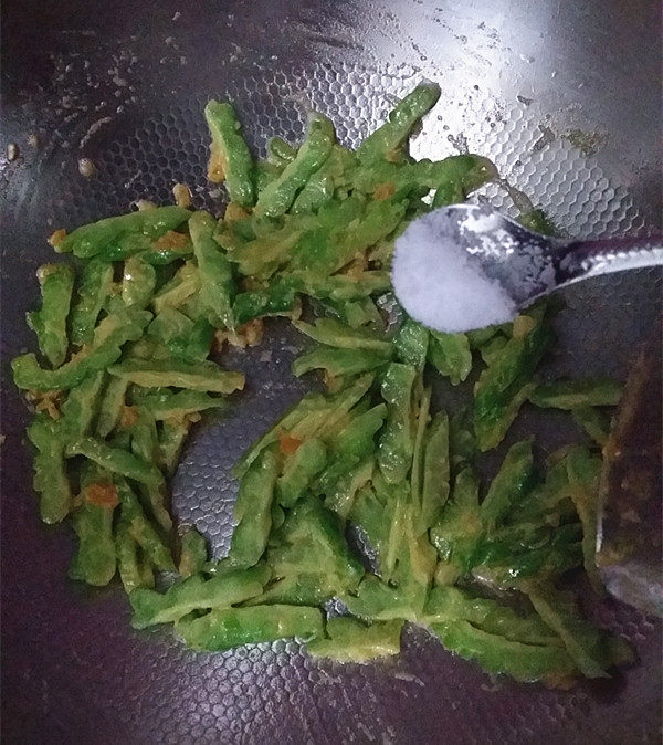 咸蛋黄焗苦瓜,待苦瓜上裹满蛋黄后，加入少许的食盐，炒匀