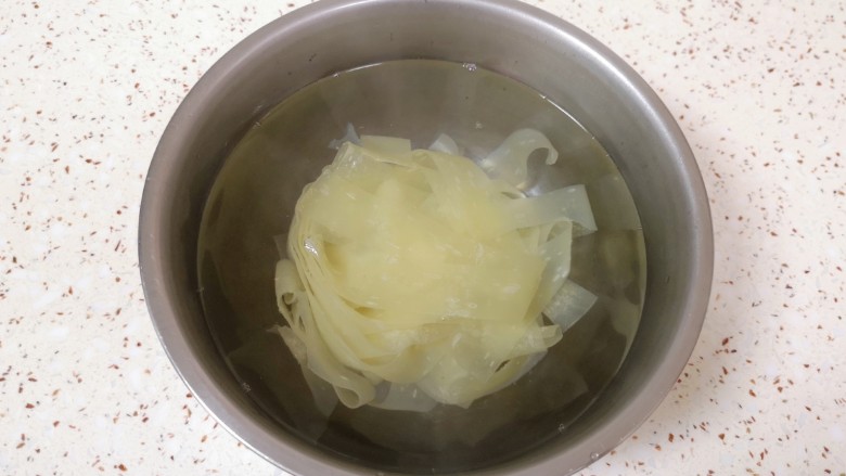 黄瓜拌面皮,加入没过面皮的开水,盖上盖子泡5分钟左右,将红油面皮里面的酱料包放在盖子上一起加热一下。