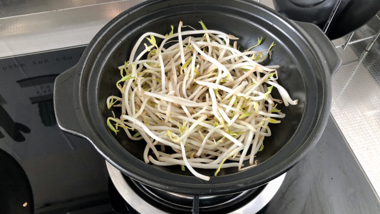 鸭血豆腐➕ 红白花开山雨中,收汁时取一个砂锅或干锅,烧热,锅底铺上绿豆芽