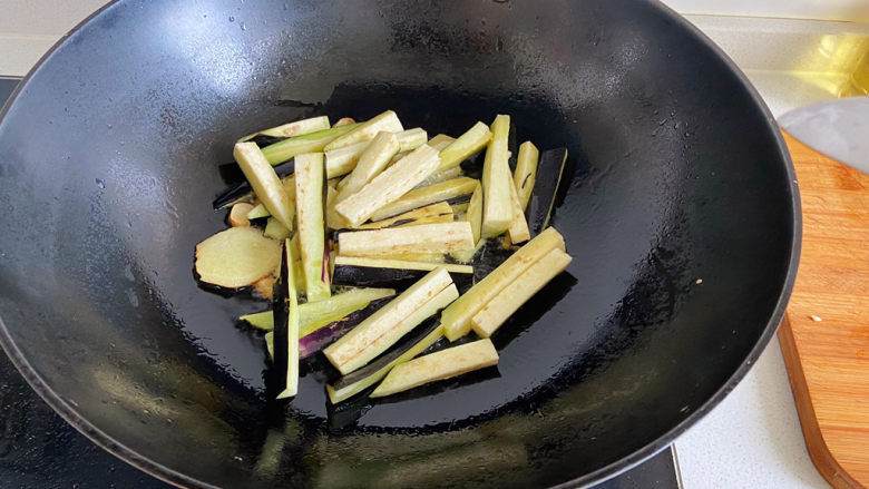 茄子烧带鱼,冰糖溶化，将茄子倒入锅中煸炒。