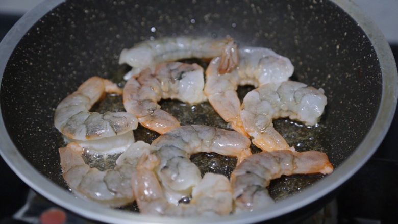 玉米炒虾仁,锅里倒少许油,烧热后放入虾仁慢煎