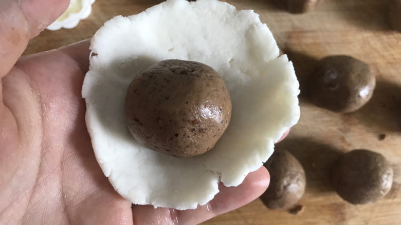 山药红枣糕,取一块山药球,用手压成圆形饼状,包入豆沙枣泥