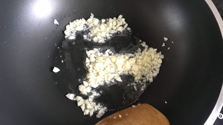 蒜蓉粉丝蒸金针菇,起锅热油下入蒜末,小火炒