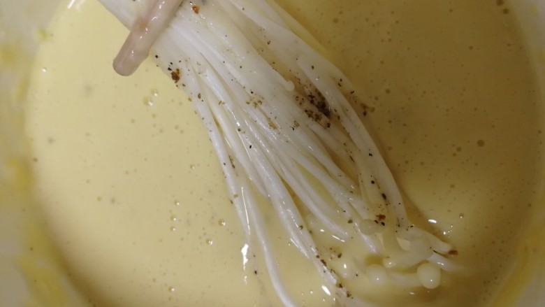油炸金针菇,取一束金针菇,全部蘸上蛋糊。