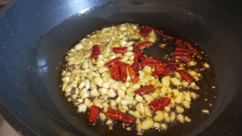 香菇炒豇豆,锅中倒入适量油烧热倒入蒜末,干辣椒。