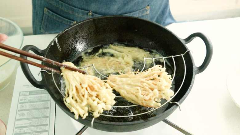 油炸金针菇,炸至金黄，酥脆后控油捞出