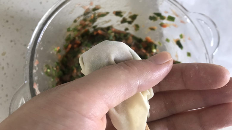 三鲜小馄饨,用手虎口夹住馄炖的尾巴,另一手拿筷子迅速抽出,一个混沌就好了