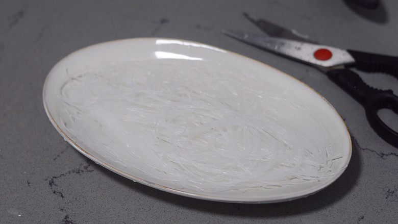 蒜蓉粉丝蒸金针菇,用剪刀剪成小段,均匀的铺在盘里