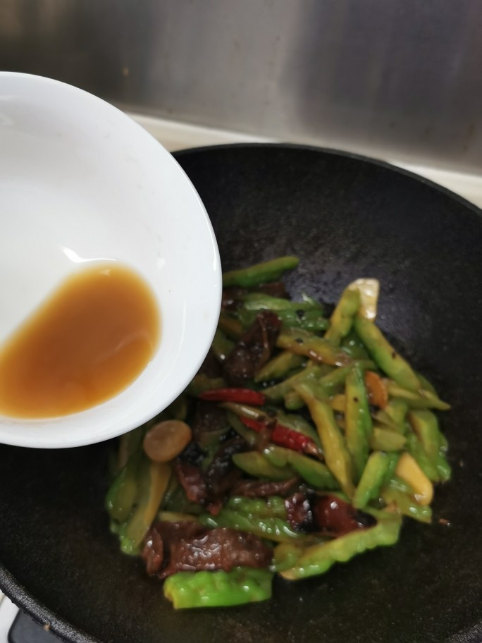 苦瓜炒腊肉,开盖加盐、糖调味,<a style='color:red;display:inline-block;' href='/shicai/ 692'>酱油</a>开淀粉水打芡。