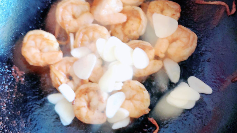 荷兰豆炒虾仁,再加入蒜片,继续翻炒。