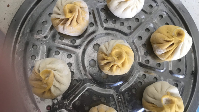 双色豆沙包,放在蒸屉(刷油)上二次醒发20分钟,检查是否醒发好,用手轻轻按包子能快速回弹就是醒发好了,用手拿起来轻飘飘