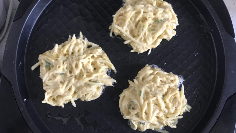 黄金土豆丝饼,用筷子夹一坨土豆丝面糊放在锅内,用筷子稍微整理成圆形
