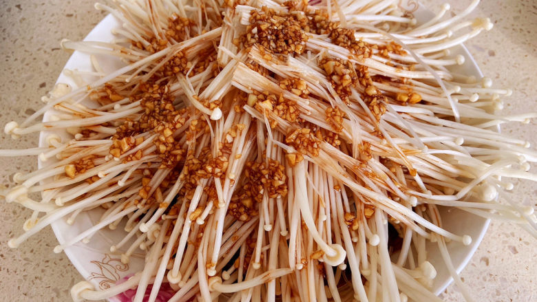 蒜蓉粉丝蒸金针菇,先把粉丝铺在盘子底部,把金针菇沿着盘子摆一圈,也可以竖直摆一排,怎么摆都行。
