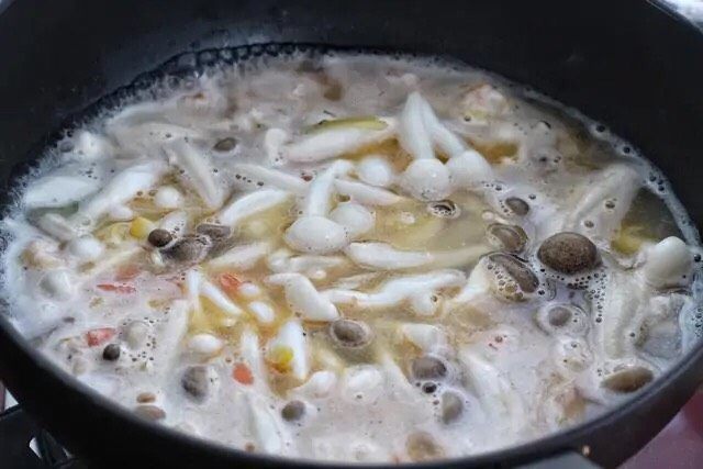 虾仁豆腐羹,然后放入蟹味菇、白玉菇和冷冻蔬菜,大约煮2-3分钟。