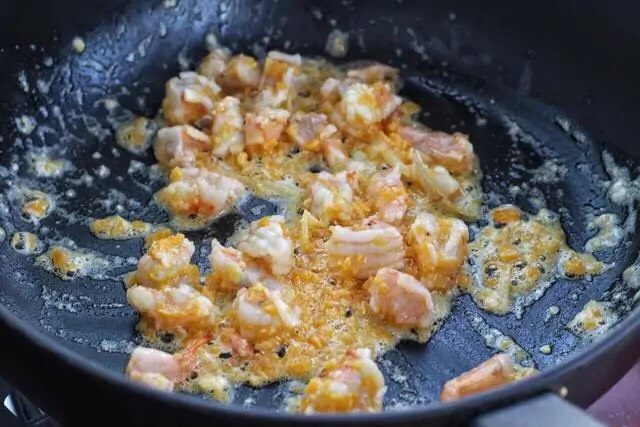 虾仁豆腐羹,接着放入蛋黄炒出泡沫,再将虾仁丁放进去翻炒变色,淋入<a style='color:red;display:inline-block;' href='/shicai/ 718'>料酒</a>翻炒均匀。