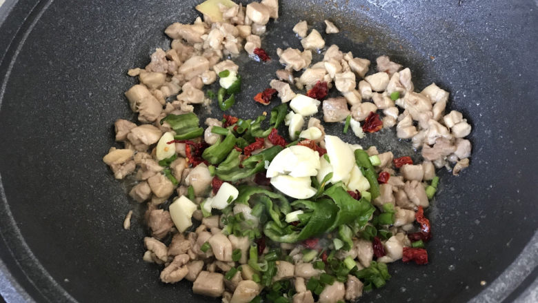 毛豆炒鸡丁,加入葱姜蒜青椒和干红椒炒匀;
