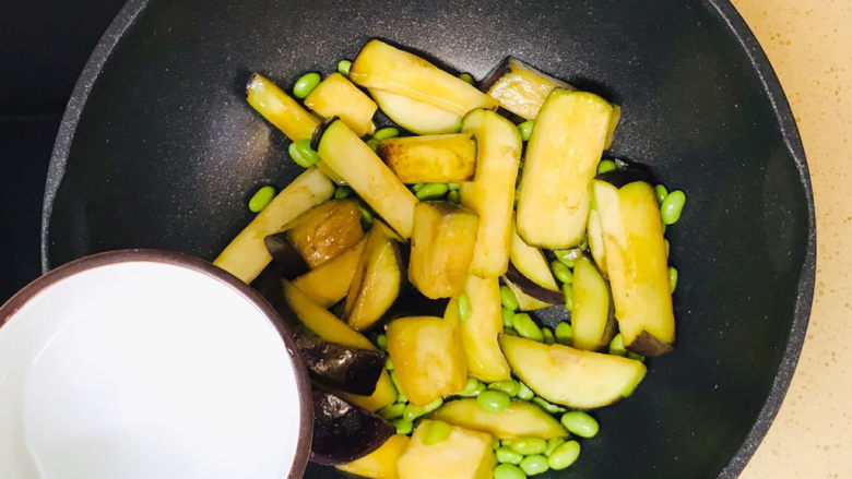 毛豆烧茄子,煸炒均匀后,加半碗水
