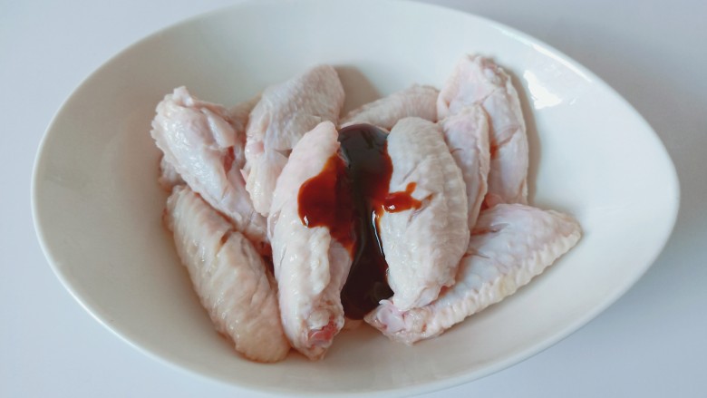 干锅麻辣鸡翅,把鸡翅放入碗里,加入蚝油2勺。