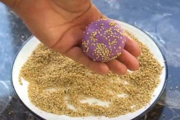 紫薯芝麻饼,然后在裹上一层芝麻,压成饼状,紫薯芝麻饼就出来了,当然现在还是生的,要煎过之后才能吃