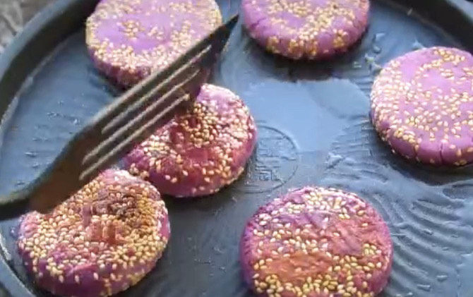紫薯芝麻饼,煎得一面泛黄了,翻面继续煎,全程多翻几次,也可以盖上盖子小焖一会,这样熟得快
