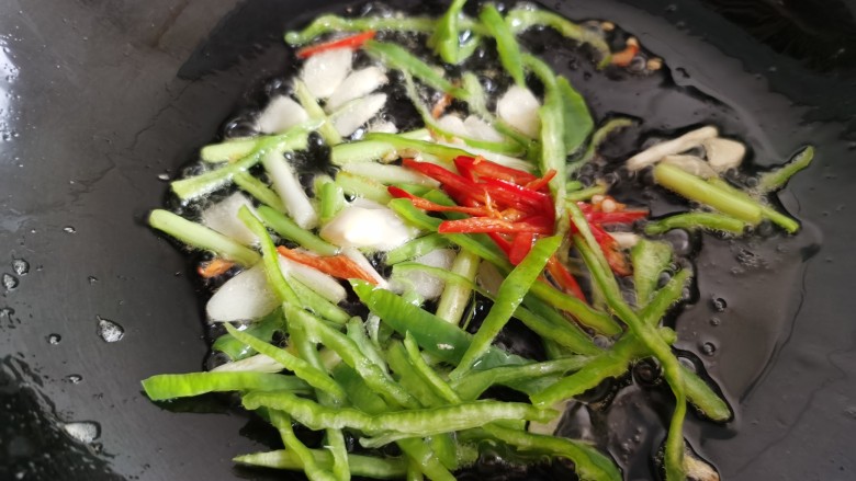 金针菇炒蛋,利用锅里的底油,加入葱、蒜,辣椒翻炒。