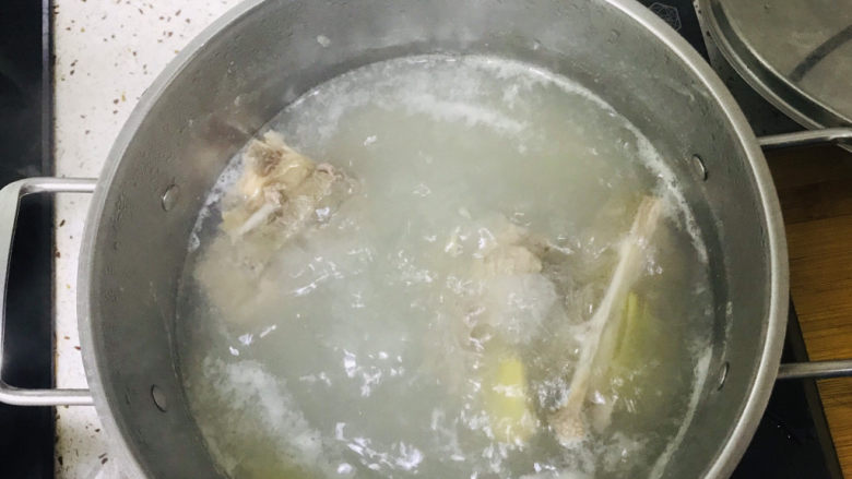 金汤花胶鸡,用焯完鸡腿后的水把脊骨煮出血沫