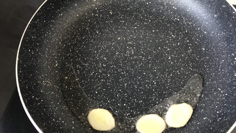 毛豆烧茄子,锅中倒入适量油,放入姜片煎出香味儿;