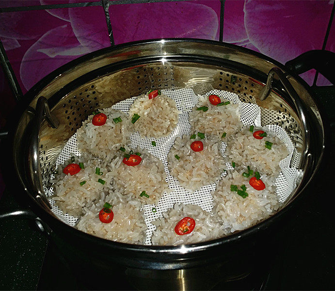 莲藕肉丸,将切好的葱花和红椒圈,放在丸子上,再蒸一分钟关火