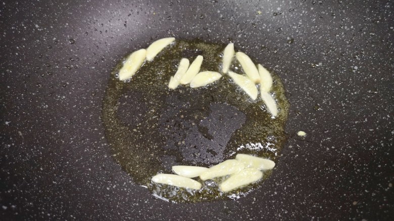 金针菇炒蛋,锅里继续倒入食用油烧热,下入蒜片炒香。