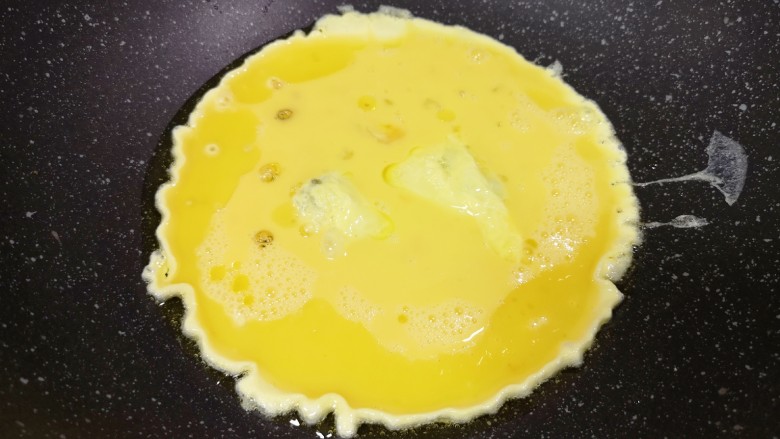 金针菇炒蛋,炒锅内倒适量的食用油烧热,倒入蛋液。