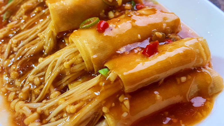 豆皮金针菇卷,把锅中的汤汁均匀淋到豆皮卷上面,最后撒点葱花和小米椒点缀。