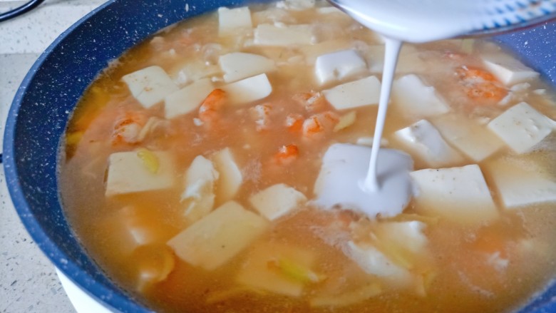 虾仁豆腐羹,加点盐调味,淋上水淀粉,一边倒一边用勺子搅拌均匀。