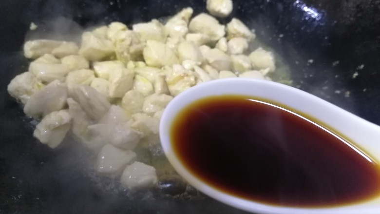 毛豆炒鸡丁,鸡丁刚一炒变色,放入一汤匙<a style='color:red;display:inline-block;' href='/shicai/ 788'>生抽</a>,急火快速炒匀。