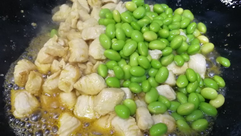 毛豆炒鸡丁,放入毛豆,急火炒匀。