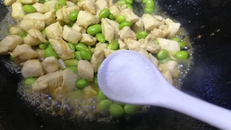 毛豆炒鸡丁,放入一小勺盐,急火炒匀入味。