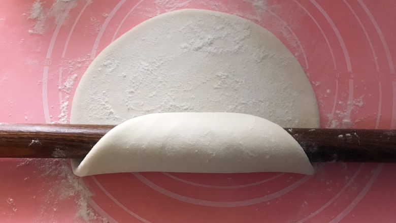 油泼手擀面,再撒点干面粉，像这样卷起来，用两个手掌用力推，然后展开，换个方向继续这个动作，直到自己满意的厚度。（我这个是两个人的量，如果家里案板比较小，可以分两份来擀）