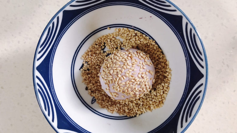 紫薯芝麻饼,把紫薯糯米团放入芝麻碗里滚一圈
