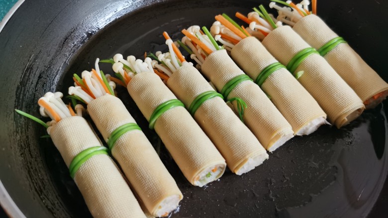 豆皮金针菇卷,锅放油烧热,放入豆皮卷煎一下。