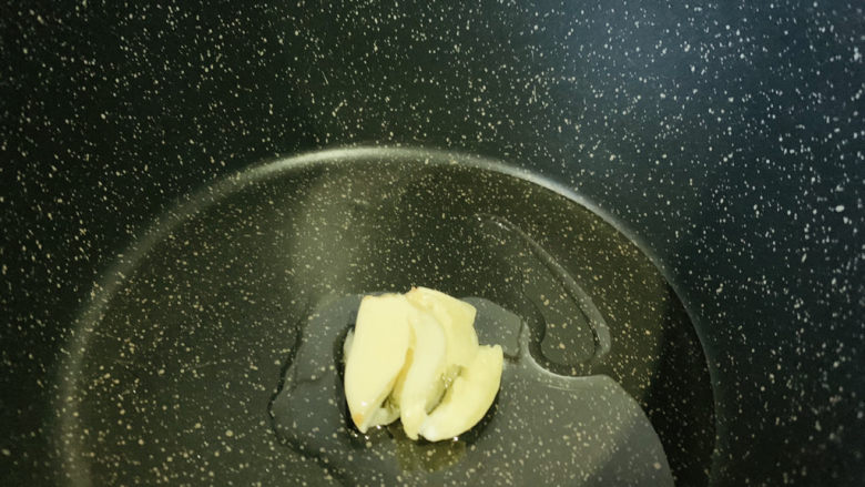 苦瓜炒虾仁,锅加食用油和蒜瓣,大火热锅,炒香蒜瓣