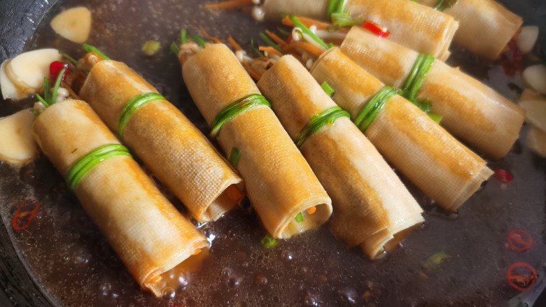 豆皮金针菇卷,倒入调好的料汁,烧煮入味后即可。