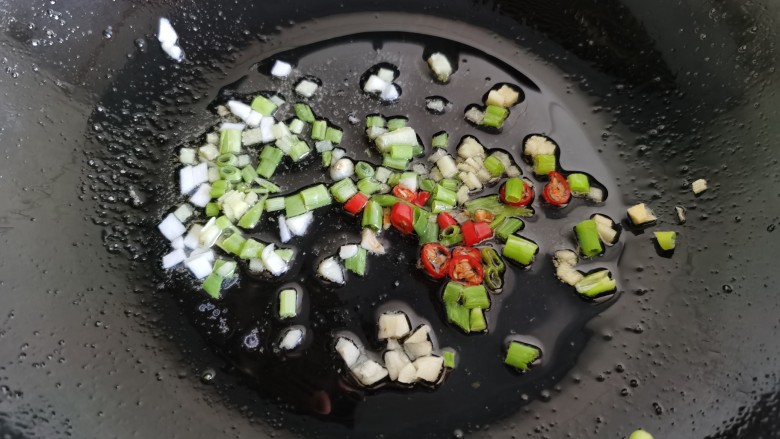 毛豆烧茄子,炒锅加入葱姜蒜炒出香味。