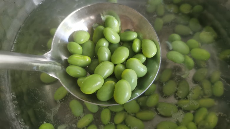 毛豆烧茄子,锅里水烧开,下入毛豆焯水后捞出备用。。