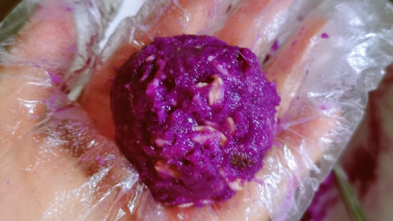 紫薯芝麻饼,取一份紫薯泥,团成球状