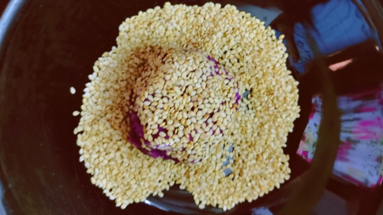 紫薯芝麻饼,放入芝麻里 压扁 同时反正面沾满芝麻