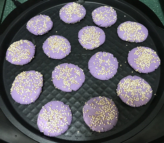 紫薯芝麻饼,电饼铛预热好,刷少许油,放入紫薯芝麻饼;还可以在饼上面也刷层油;我家不喜欢油腻的,就没刷了
